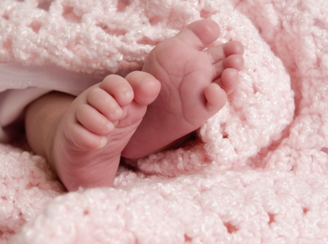 Baby wrapped inside pink blanket
