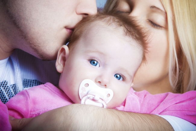 Couple happy and kissing their newborn