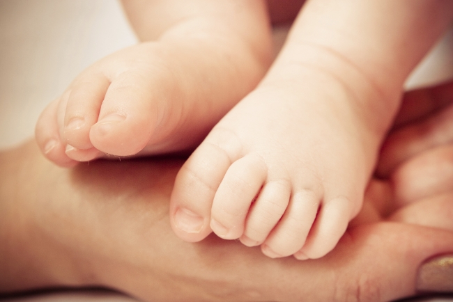 Baby feet in the palm of hands